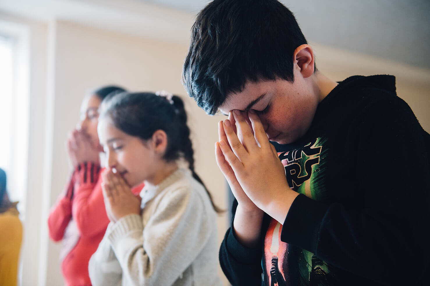 Children praying during a lesson.