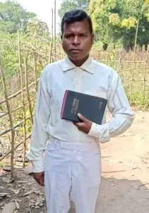 Ganesh standing with a Bible in his hand