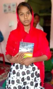 Lalita standing holding a book